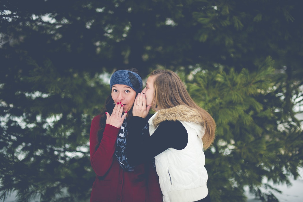Two girls gossiping.